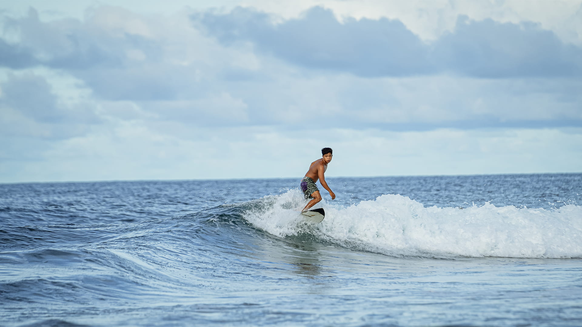 image of a surfer off the coast of Puraran